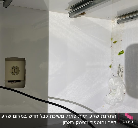 שקע חשמל עם כבל חשמלי בתוך ארון